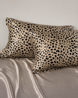 Two leopard print pillows on a beige bedspread - 100% 6A Grade Mulberry silk