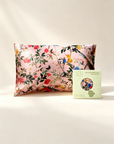 Floral-patterned pillow and a green box with a circular design on a light background