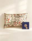Decorative pillow with floral and bird pattern on a white surface, accompanied by a blue packaging box. 100% Mulberry Silk Pillowcase in 25 Momme